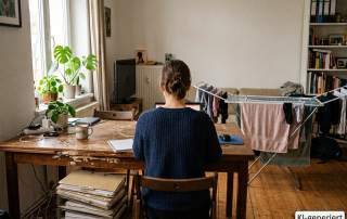 Frau sitzt an ihrem provisorischen Arbeitsplatz im Homeoffice – KI-generiert